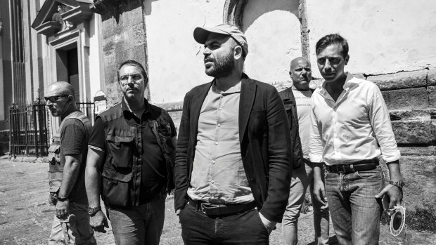 Roberto Saviano, centre, an Italian journalist, writer and essayist, with his police escort in Naples, Italy.