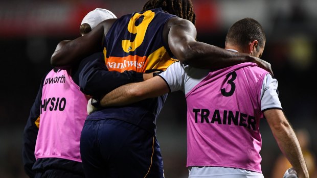 Nic Naitanui limps from the ground on Friday night.