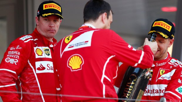 Not happy: Ferrari driver Kimi Raikkonnen (left) made clear in post-race interviews that he was not pleased with team strategy that appeared to favour teammate Sebastian Vettel.
