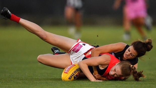 Sarah Lampard of the Demons is tackled by Collingwood's Stephanie Chiocci.