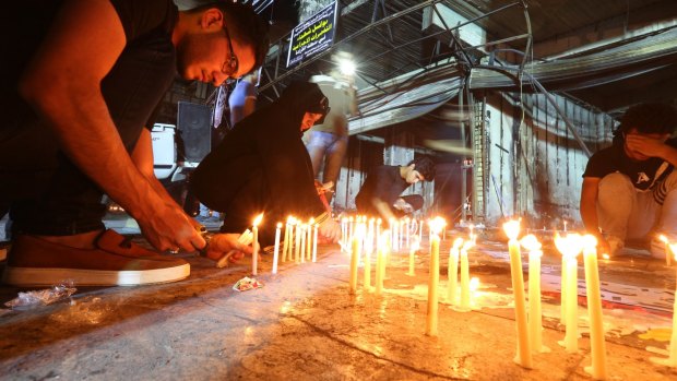 People light candles at the scene of the massive car bomb attack in Iraq.