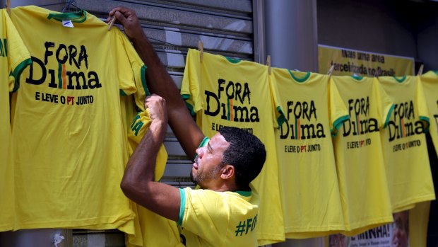 A vendor hangs shirts reading 'Out, Dilma' during a protest against Brazil's President Dilma Rousseff in Sao Paulo on Sunday.