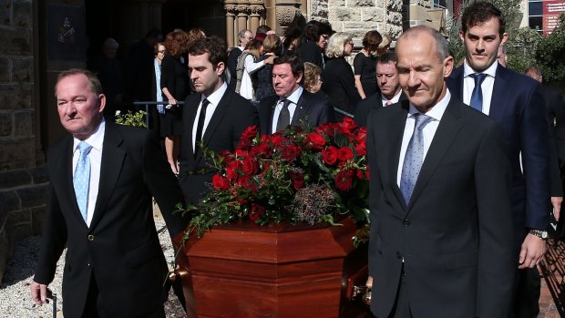 Craig Bond and John Bond lead the funeral prosession with the casket of their father Alan Bond.