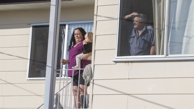 Neighbours watch a TV helicopter overhead near the house of Schapelle Corby's mother in Loganlea.