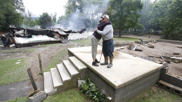 Jimmy Scott gets a hug from Anna May Watson, left, as they clean up from severe flooding in White Sulphur Springs, West Virginia. Scott lost his home to the flood and a fire that consumed his and the homes of several relatives. 