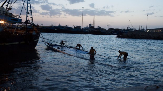 Dredging up a tragedy: A sunken boat carrying migrants is pulled in to the port of Zuwara.