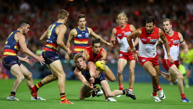 Adelaide’s Rory Sloane is tackled by Sydney’s Josh Kennedy during Saturday night’s semi-final at the SCG.
