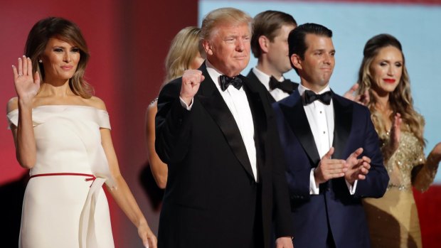 US President Donald Trump, centre, raises his fist alongside First Lady Melania Trump, left, and son Donald Trump Jr, right, and Eric, behind, at the Liberty Ball in Washington. 