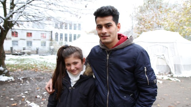 Yazidi refugee Renda Barakat, 11, with Majid Dhalriaiyam, 17, from Afghanistan outside a snow-covered refugee shelter in Germany. 