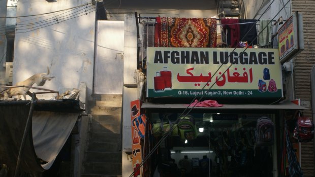 An Afghan luggage store's sign is in English and Farsi in Delhi's Little Kabul district.