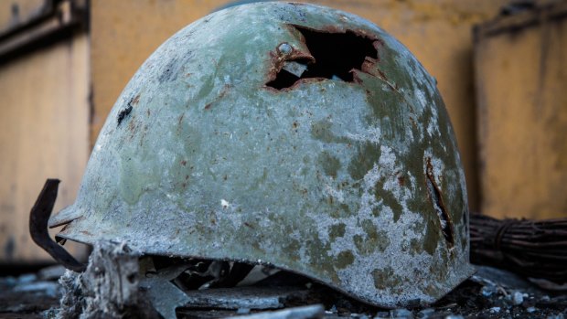 A battered Ukrainian army helmet in Yenakievo, Ukraine. Rebels claim they have withdrawn heavy weapons from the front line.