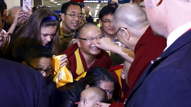 Exiled Tibetan spiritual leader the Dalai Lama pinches the nose of a supporter after arriving in Sydney on Thursday.