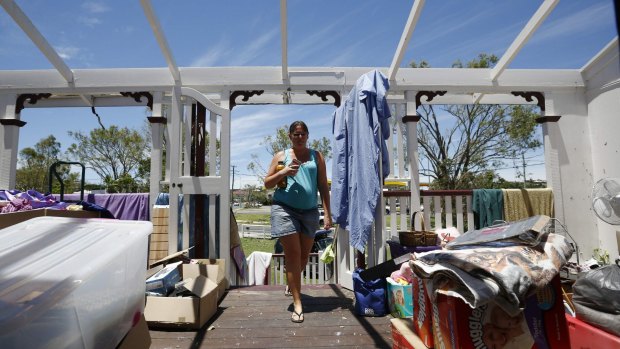 Yeppoon resident Demelza Bischoff walks onto the roofless veranda of her home on Saturday, after it was damaged during Cyclone Marcia.