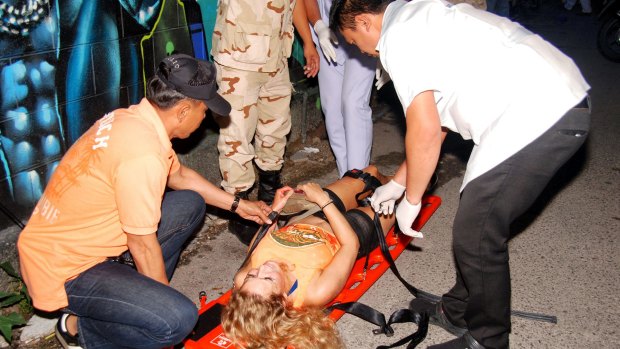 Rescue workers help an unidentified woman after a bomb blast in  Hua Hin on Thursday.