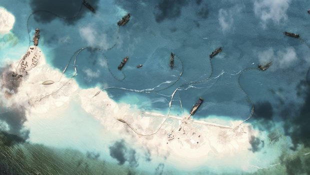 A handout satellite image shows dredgers working at the northernmost reclamation site of Mischief Reef, part of the Spratly Islands, in the South China Sea, March 17, 2015.