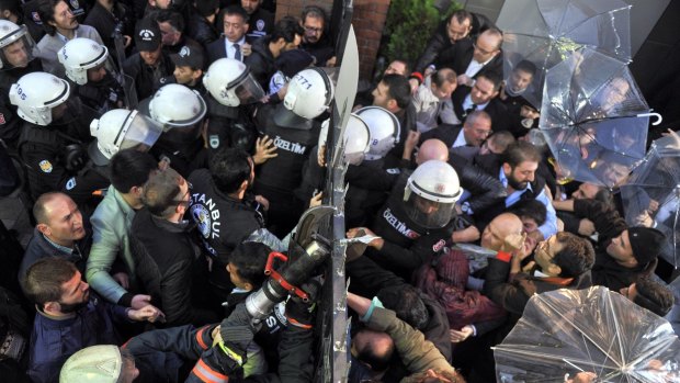 Riot police force a gate to enter the headquarters of opposition television stations and newspapers with ties to a movement with links to Islamic cleric Fethullah Gulen, in Istanbul, Turkey, last week.