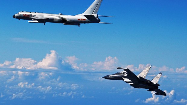 A Chinese People's Liberation Army Air Force Su-30 fighter, right, flies along with a H-6K bomber as they take part in a drill near the East China Sea in September.