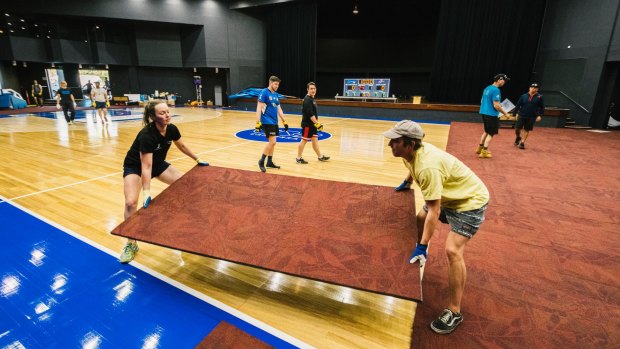 Workers remove panels to reveal the basketball court at the National Convention Centre.