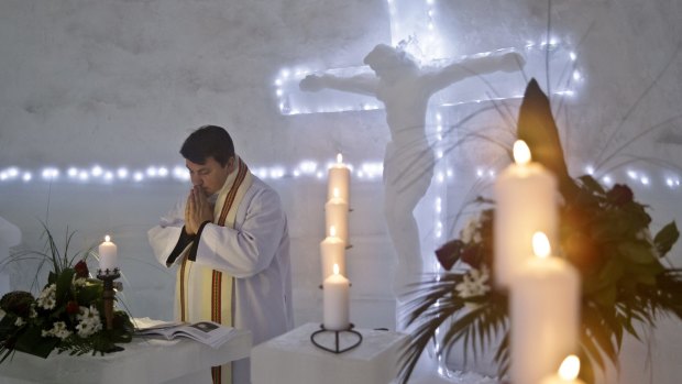 A Romanian priest prays inside a church built entirely from ice blocks cut from a frozen lake at the Balea Lac resort in the Fagaras mountains, Romania.