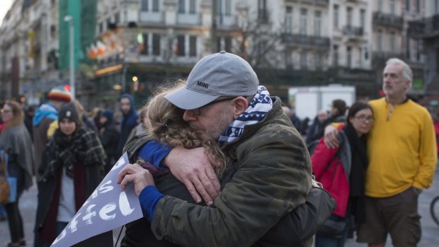 Mourners embrace at Beursplein square in Brussels, Belgium, on Tuesday.
