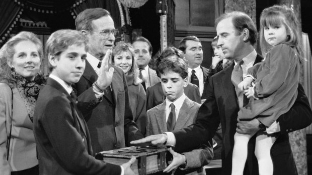 Beau Biden (foreground) and his brother Hunter hold the family Bible as their father Joe re-enacts his swearing-in as US senator for Delaware in January 1985 with then US vice-president George Bush snr.
