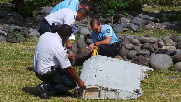 French police inspect the flaperon, now confirmed to be from MH370, on Reunion Island.