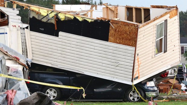 Part of a building sits on a vehicle at Prairie Lake Estates trailer home park.