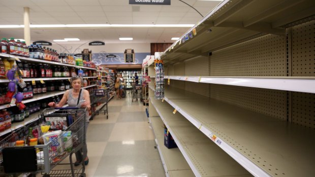 A shopper finds empty shelves on the bottled water section of a grocery store on in preparation of Hurricane Harvey in Houston.