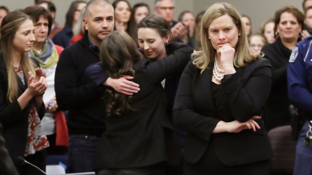 Former gymnast Rachael Denhollander, centre, is hugged after giving her victim impact statement.