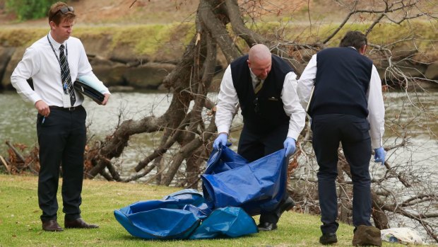 Police investigating the death of Brendan Bernard take away evidence from the banks of the Maribyrnong River. 
