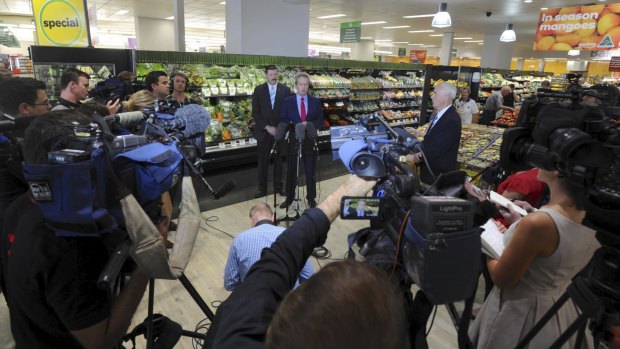 A media posse surrounds Bill Shorten in a Queanbeyan Woolworths store.