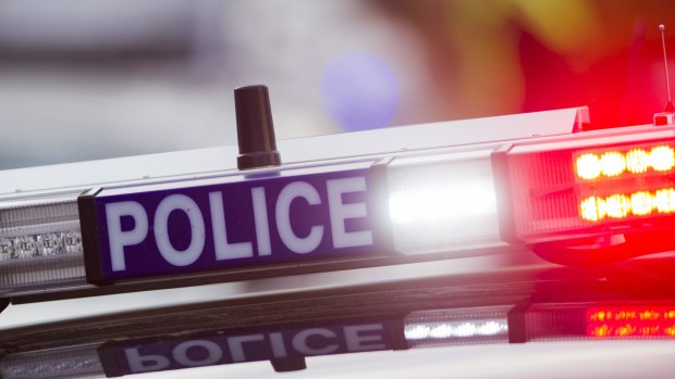 A man and woman have armed themselves in a Townsville house with two children inside.