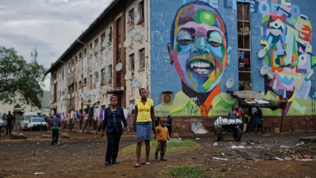 Women walk past their apartment block in the low-income neighbourhood of Mbare in Harare.