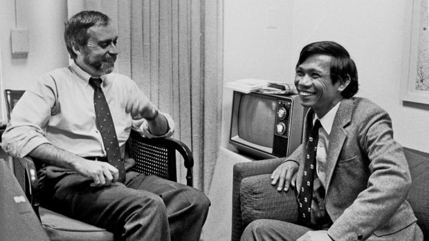 Sydney Schanberg, left, talks with Dith Pran at the New York Times office in New York in 1980.