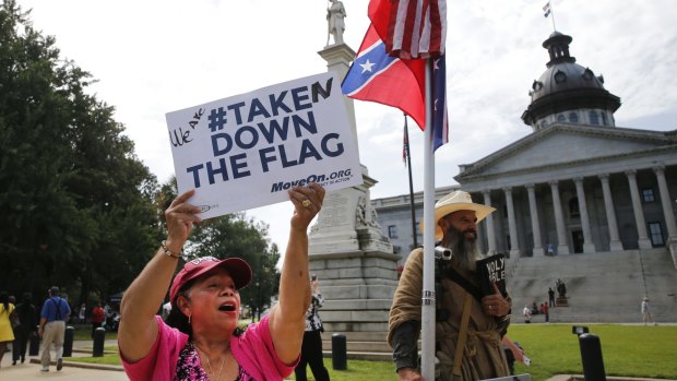 Maria Calef, of Columbia, South Carolina, waves a sign as she celebrates in front of the South Carolina statehouse.