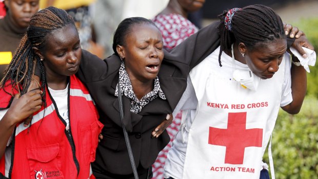A relative is helped by Kenya Red Cross staff after visiting Nairobi's Chiromo Mortuary to identify bodies of students killed in the April 2 university massacre.