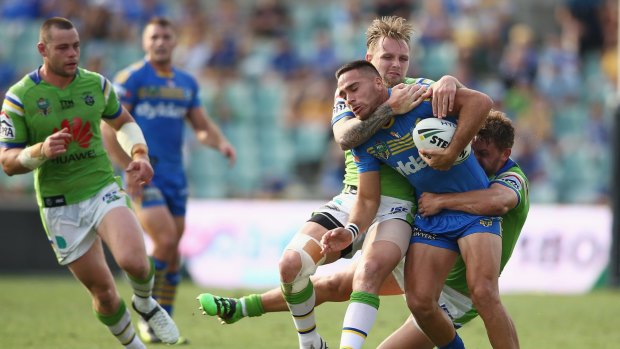 Corey Norman of the Eels is tackled by Blake Austin and Shaun Fensom of the Raiders.
