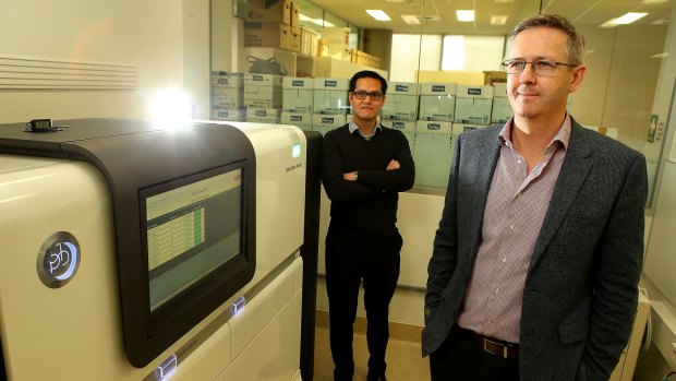 Professor Ben Howden (right), director of the Microbiological Diagnostic Unit at Melbourne's Doherty Institute, with Dr Jason Kwong and the gene sequencer that helped St Vincent's trace the source of a superbug infection in 2015 to a single toilet bowl.