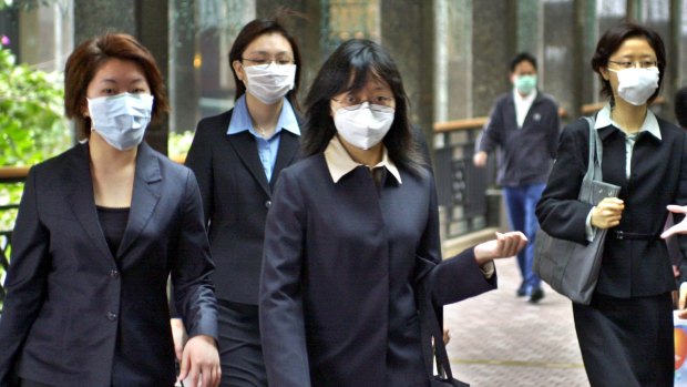 Office workers wear protective masks in downtown Hong Kong at the height of the SARS crisis in 2003.