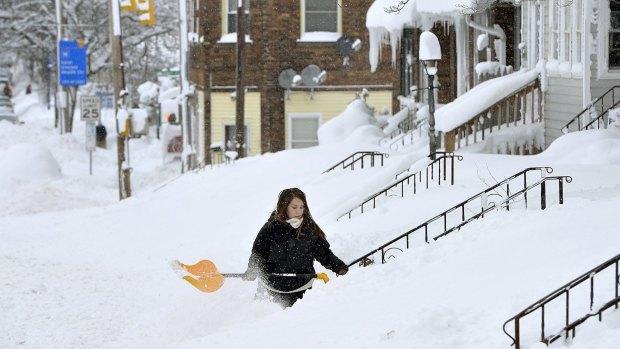 Rochelle Carlotti shovels steps near her home in Erie, Pennsylvania, after a record snowfall on Tuesday.