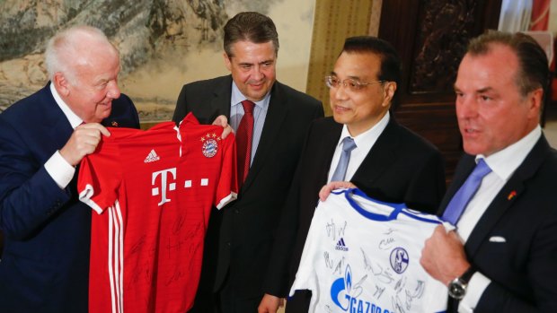 A German delegation presents Chinese Premier Li Keqiang, second right, with Bundesliga soccer shirts as he meets German Foreign Minister Sigmar Gabriel, second left, in Beijing last week.