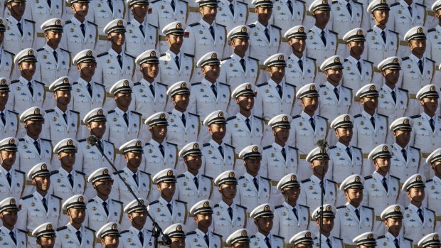 Chinese soldiers stand at attention in Tiananmen Square before a military parade.