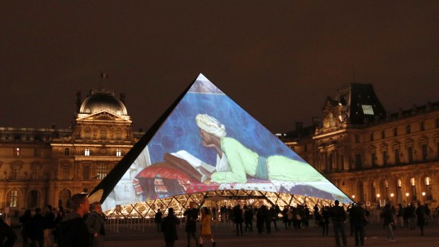 Pictures are screened on the pyramid of the Louvre museum in Paris, as part of the launch of the Louvre Abhu Dhabi. 