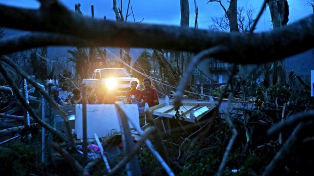 Residents sit on a couch outside their destroyed homes in Puerto Rico after Hurricane Maria.