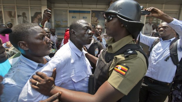 Leading opposition leader and presidential candidate Kizza Besigye is grabbed by riot police in downtown Kampala on Monday. He was reportedly arrested again on polling day.
