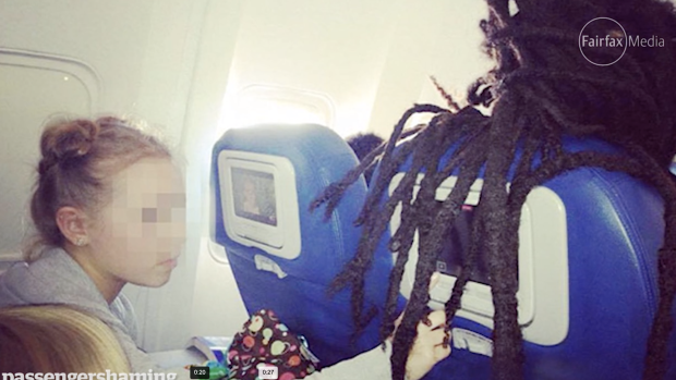 One of many passengers caught with their hair covering the inflight entertainment.