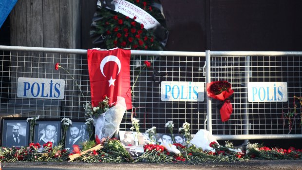 Flowers sit alongside photographs of some of the victims of the New Year's Eve attack.