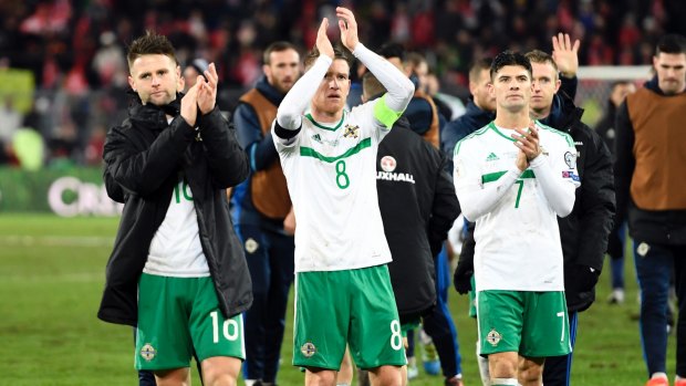 So close: Northern Ireland players applaud the travelling fans after the final whistle.