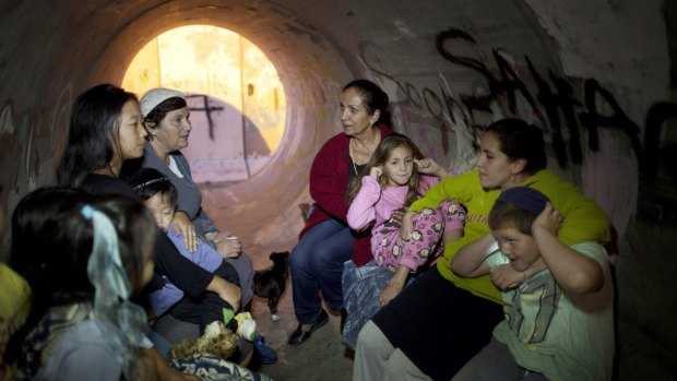 Bomb shelter: Israelis take cover in a large concrete pipe.