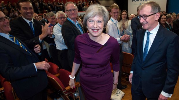 Theresa May and her husband, Philip John May, leave the Birmingham conference hall to a standing ovation.